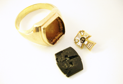 Picture of a man's ring with a barrel shaped Onyx with 2 holes and an emblem.