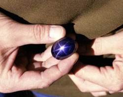 Photo of the gem dealer holding the large star sapphire.