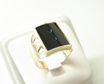 Photo of a ring with a rectangle black Onyx with 2 small holes drilled in it.