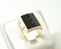 Photo of a ring with a rectangular black Onyx inlay which has an arched top surface.