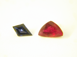 Shows a blue kite shaped Sapphire on the left and a red Ruby on the right which is a triangular shape.