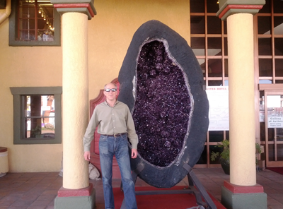 Photo of Denton next to a large Amethyst geode at the Tucson gem show.