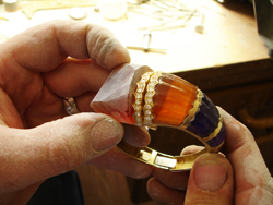 Photo of our carver carving the synthetic Citrine to fit the bracelet.