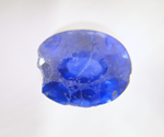 Photo of an oval blue Sapphire which has a lot of chips on the crown.