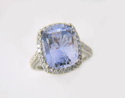 Shows the same light blue Sapphire which has now been repaired and is sitting in the diamond ring mounting.