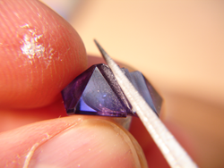 This shows me using a diamond file to sand down the Amethyst to remove the chip.