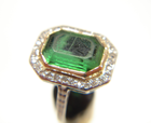 Picture of a green stone with a scratched table which is set in a ring.