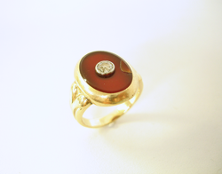 Shows a ring with dark red Carnelian cabochon which has a chip in it.