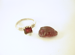 A piece of rough uncut Rhodolite Garnet next to the ring with the broken one.