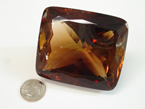 A large cushion shaped brownish colored faceted Topaz.