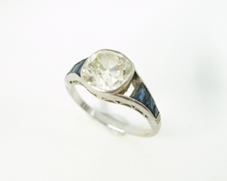 A white gold Diamond ring which is missing a Sapphire.