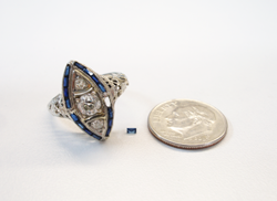 The white gold antique filagree ring and the new tiny Sapphire baguette sitting next to the ring.