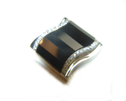It is now finished and set into the cufflink mounting which is white gold and has diamonds on each side of the Onyx.