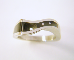Photo of the ring which has had holes drilled to put the Diamond and also 2 small white gold dots.
