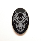 Photo of an oval black Onyx with the white image of a wolf on it which was made with a laser.