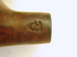 A closeup shot of the initials in the side of their wooden pipe.