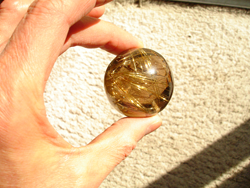 Shows me holding the finished Rutillated Quartz sphere.