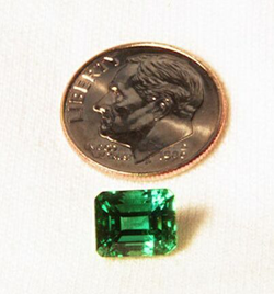 Picture of an Emerald next to a dime.