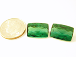 Photo of a pair of cushion green Tourmaline. One of them has a chip.