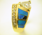 Photo of an Opal ring with a trillion diamond a brokenopal inlay.