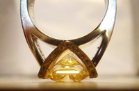 Picture of a ring with a yellow gem face down on the table.