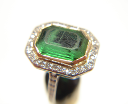 Green Tourmaline that is very scratched and in a ring .