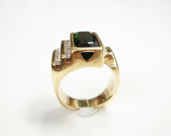 Photo of a ring with a row of Diamonds and a rectangular blue-green Tourmaline which has a scratched table.